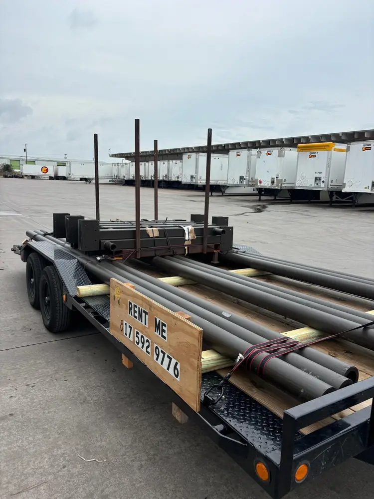 Car hauler trailer loaded with steel pipe and lumber
