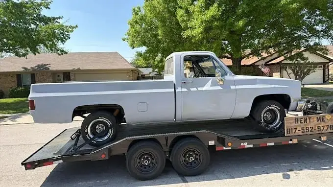 Silver classic Chevrolet pickup on the car hauler trailer
